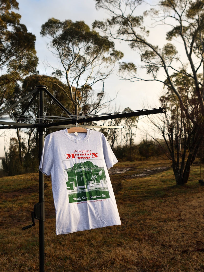 White t-shirt with graphic design hanging on a clothesline outdoors